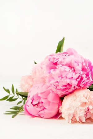 A bouquet of fresh beautiful flowers lies on a white background. Pink peonies lie . Vertical photoの写真素材