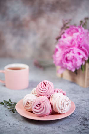 Homemade berry marshmallow in a plate is on the table with a Cup of tea.の写真素材