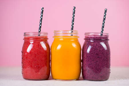 Three jars of fresh vegan smoothies made from natural fresh fruits and berries. The concept of a clean and healthy diet.の写真素材