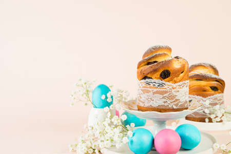 Festive Easter cake and painted eggs lie in a still life on a trendy pastel background. Banner,...