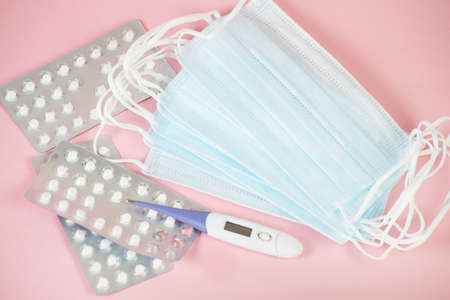 Tablets in a blister , medical masks and a thermometer for the treatment of infections, coronavirus...