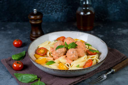 Italian Penne pasta with meatballs, tomatoes and aromatic herbs, selective focusの写真素材