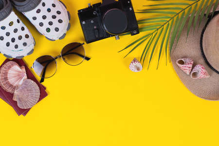 Flat accessories for travelers on a colored background with a straw hat, camera, and sunglasses.の写真素材