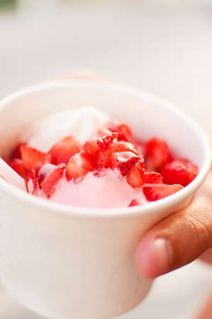 Summer street dessert, frozen yogurt with strawberries in a Cup