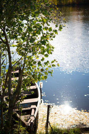 Wooden boat in the pond in the autumn Park, autumn landscapeの写真素材