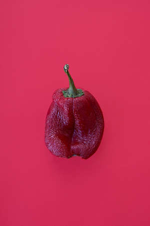 Ugly vegetables, deformed red bell peppers on a trending red backgroundの写真素材