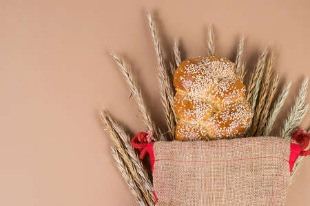 Fresh homemade bread with sesame seeds at the bakery, a trendy concept on the pastel beige...