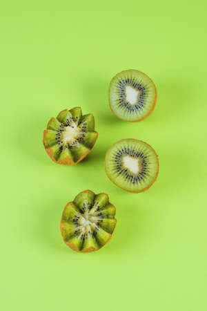 Halfs of a green ripe kiwi on a green background, top viewの写真素材