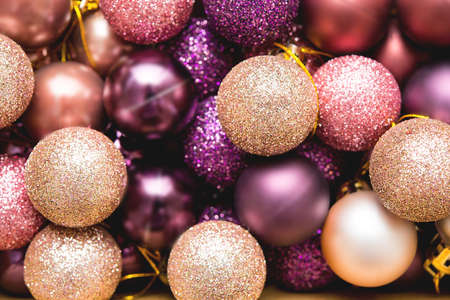 Lots of Christmas tree shiny balls on pink background, Christmas background, close upの写真素材