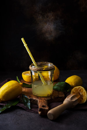 Fresh squeezed juice from lemon halves with a juicer in a glass jar, selective focusの写真素材