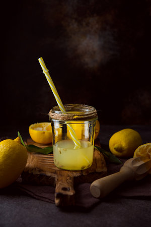 Fresh squeezed juice from lemon halves with a juicer in a glass jar, selective focusの写真素材