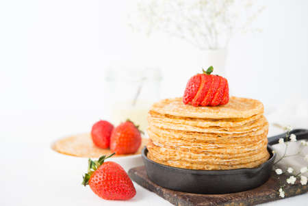 Homemade traditional thin pancakes with berries on a white background, Maslenitsa, copy of spaceの写真素材