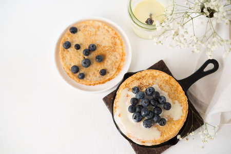 Homemade thin traditional pancakes with condensed milk and blueberries, top view, copy spaceの写真素材