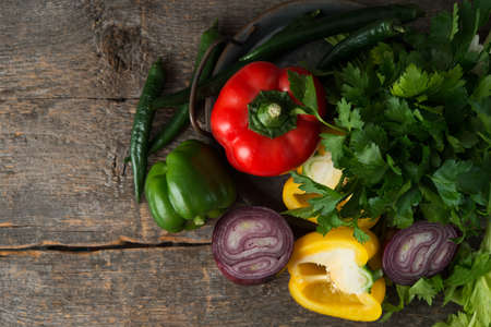 Fresh organic vegetables and herbs on a rustic wooden background, top viewの写真素材
