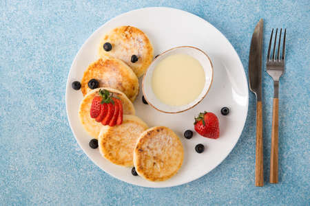 Homemade fried cheesecakes with condensed milk and berries, top viewの写真素材