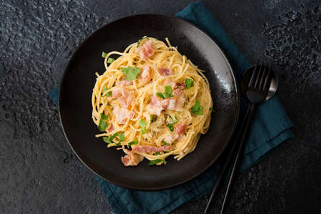 Pasta carbonara with bacon and parmesan on a plate, top viewの写真素材