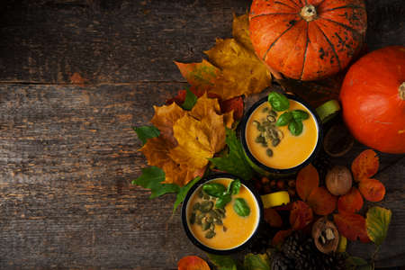 Autumn pumpkin soup with pumpkin seeds in a tin cup, Thanksgiving, rustic style, top viewの写真素材