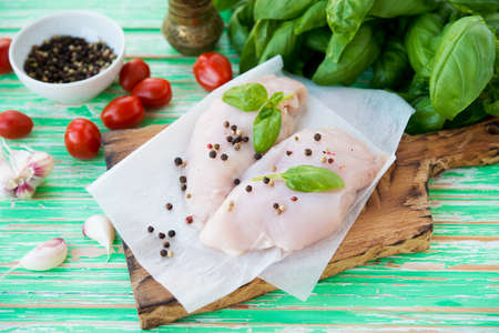 Raw chicken breast marinated for baking on a wooden board, selective focusの写真素材