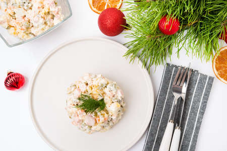 Traditional New Year's salad olivier with festive decorations on a white background, top viewの写真素材