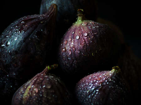 Ripe fresh figs in a tin cup on a dark background, horizontal orientation, southern fruitの写真素材