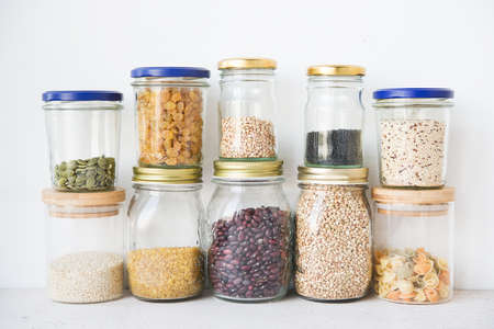 Dry cereals and seeds in glass jars, the concept of healthy nutrition (beans, quinoa, pumpkin seeds,...