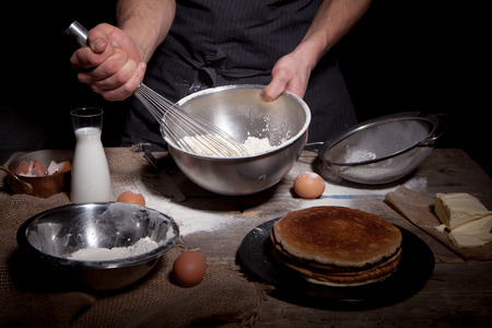 Cook preparing dough on a rustic tableの写真素材