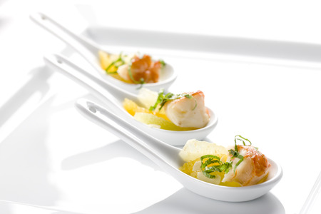 orange shrimp appetizer in decorative spoonの写真素材
