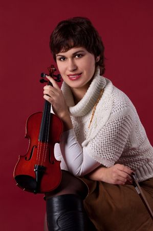 the girl is sitting and holding a violinの写真素材