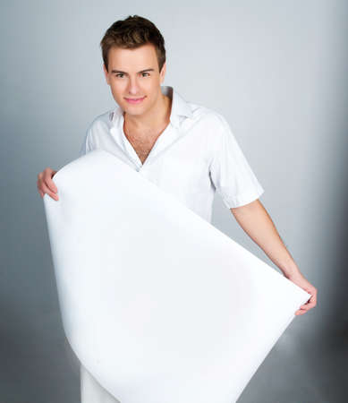 handsome young man holding a paperの写真素材