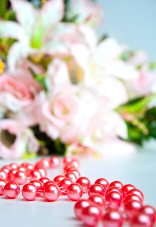 red beads on a background of a bouquet of flowersの写真素材