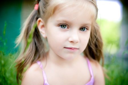 cute little girl smiling in a park close-up