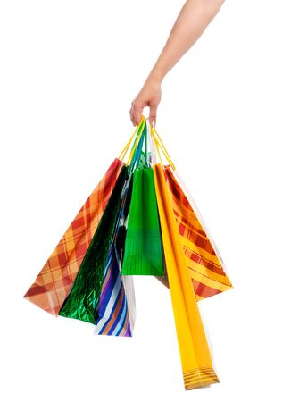 Female hand holding colorful shopping bags on whiteの写真素材