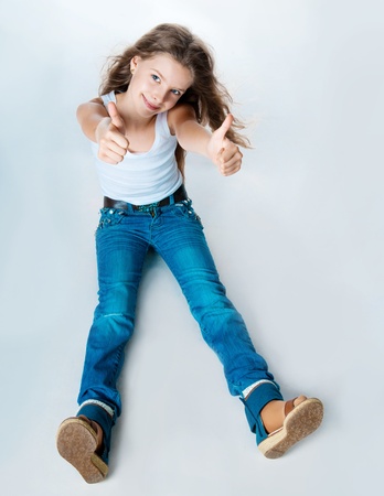 cute girl with thumbs up on a white backgroundの写真素材