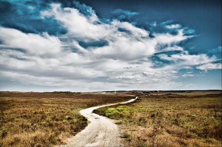 country road to the mountains with blue skyの写真素材