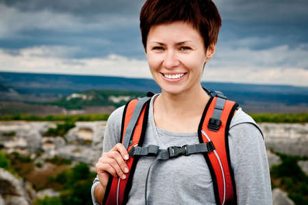 girl with a backpack on a mountain topの写真素材
