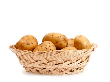 Potatoes in a wicker basket isolated on white backgroundの写真素材