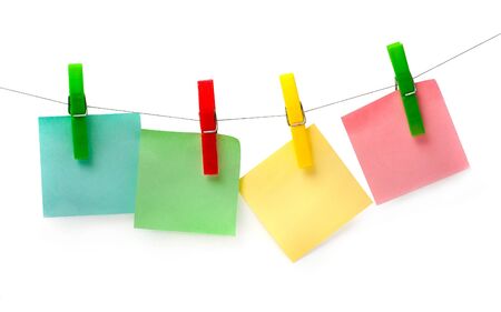 three colored piece of paper for notes hanging on pegsの写真素材