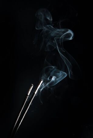 incense with smoke on black backgroundの写真素材