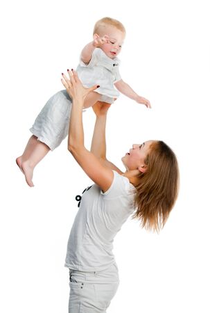Mom raises her little boy over her headの写真素材