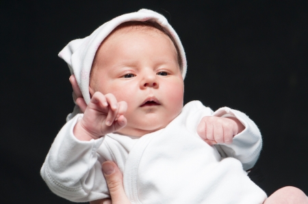 baby in mother s hands over blackの写真素材