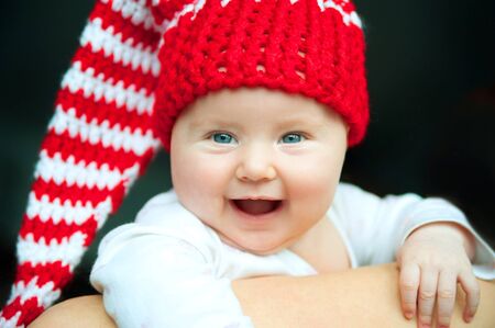 smiling pretty baby in red hatの写真素材