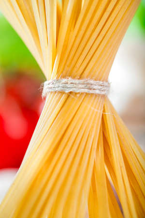 uncooked spaghetti tied with ropeの写真素材