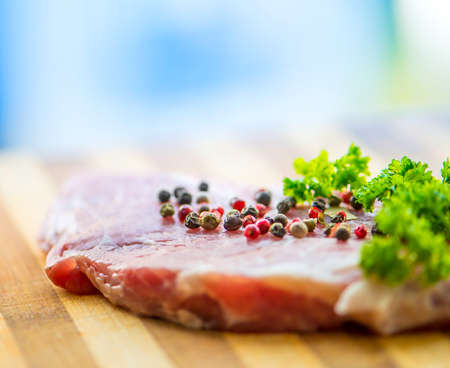 raw meat for steak with pepper and herbs on a cutting boardの写真素材