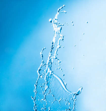 shot of water splashing on blue backgroundの写真素材