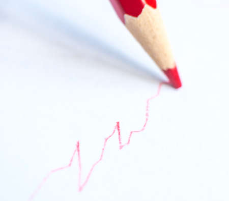 red pencil drawing graph on white paperの写真素材