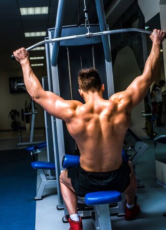 bodybuilder doing exercises on the simulator
