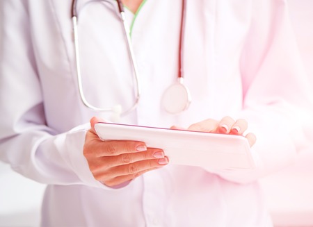 Doctor using a white digital tabletの写真素材