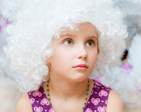 beautiful little girl in a white curly wigsの写真素材