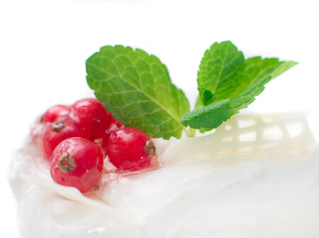 cheesecake with berries red currant and mint leaves on whiteの写真素材