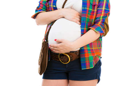 Pregnant woman in a shirt isolated on a white backgroundの写真素材